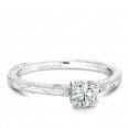 A Carver Studio engraved white gold engagement ring with a round center stone.