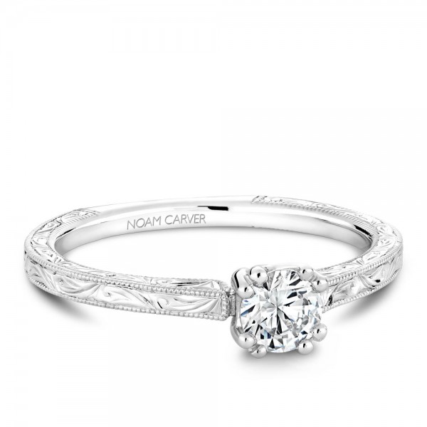 A Carver Studio engraved white gold engagement ring with a round center stone.
