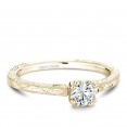A Carver Studio engraved yellow gold engagement ring with a round center stone.