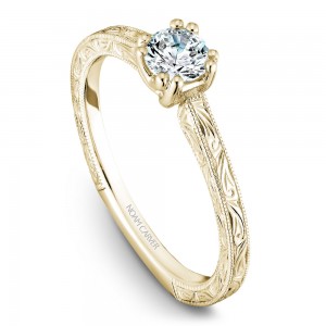 A Carver Studio engraved yellow gold engagement ring with a round center stone.