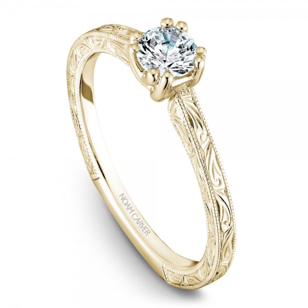 A Carver Studio engraved yellow gold engagement ring with a round center stone.