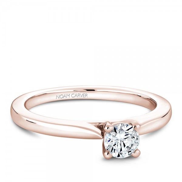 A solitaire Carver Studio rose gold engagement ring with a round center stone.