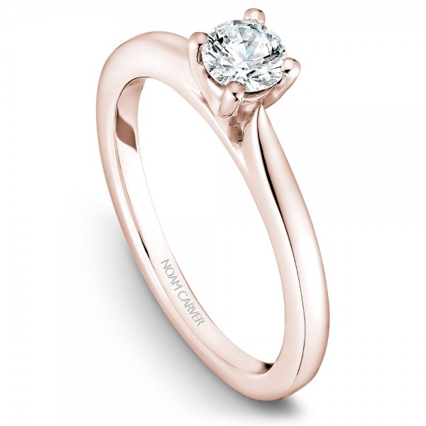 A solitaire Carver Studio rose gold engagement ring with a round center stone.
