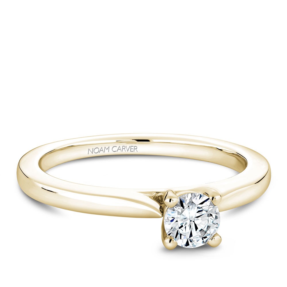 A solitaire Carver Studio yellow gold engagement ring with a round center stone.