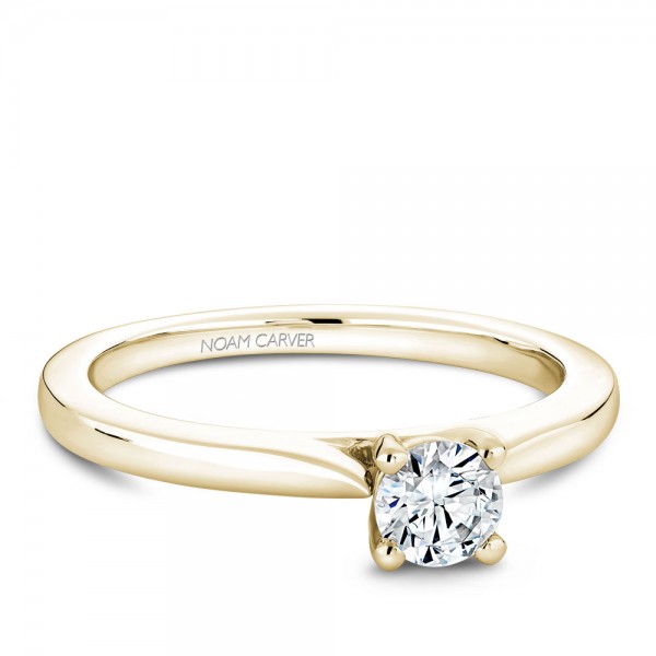 A solitaire Carver Studio yellow gold engagement ring with a round center stone.