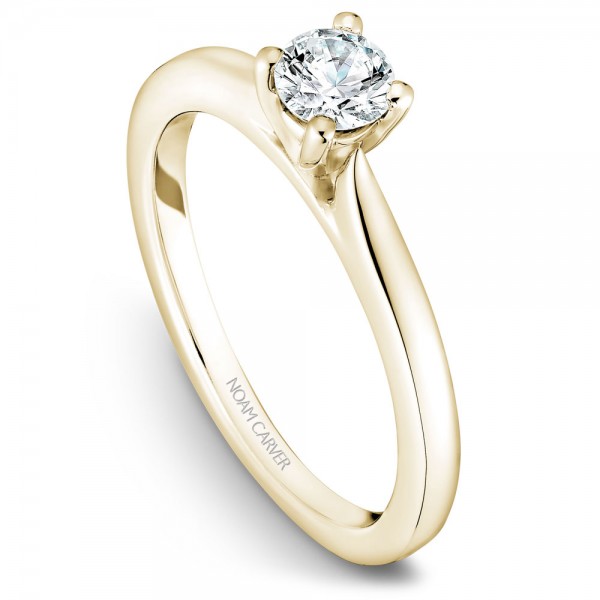 A solitaire Carver Studio yellow gold engagement ring with a round center stone.