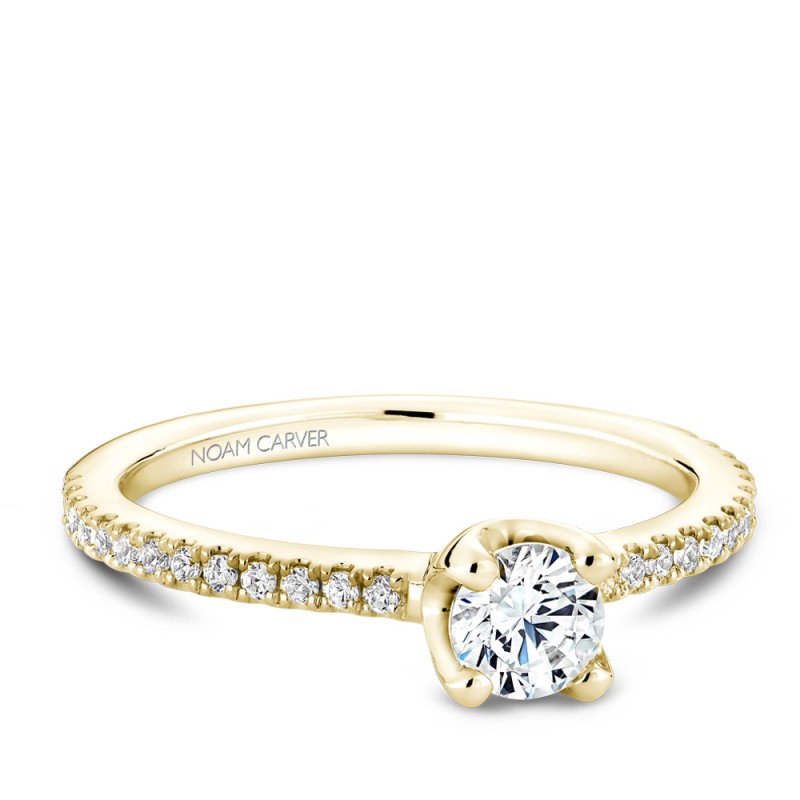 A floral Carver Studio yellow gold engagement ring with a round center stone and 27 diamonds.
